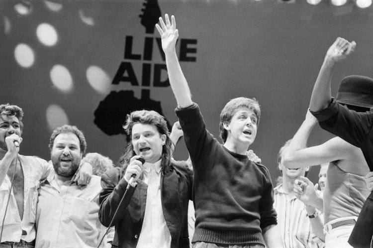 George Michael, promoter Harvey Goldsmith, U2 lead singer Bono and Paul McCartney performing